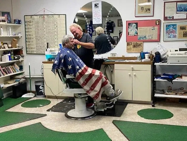 Barber with enormous amounts of sports memorabilia retires after 50 years